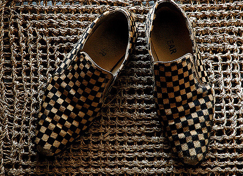 SOULIERS À CARREAUX SUR UN TAPIS EN CHANVRE